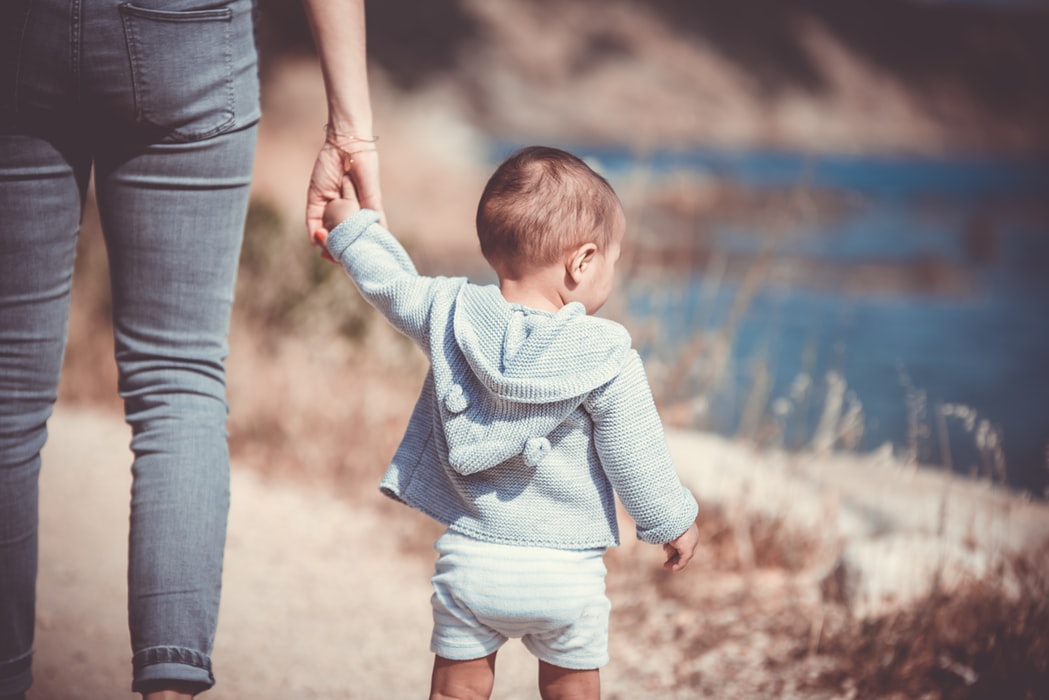 teacher-holding-childs-hand-next-to-river