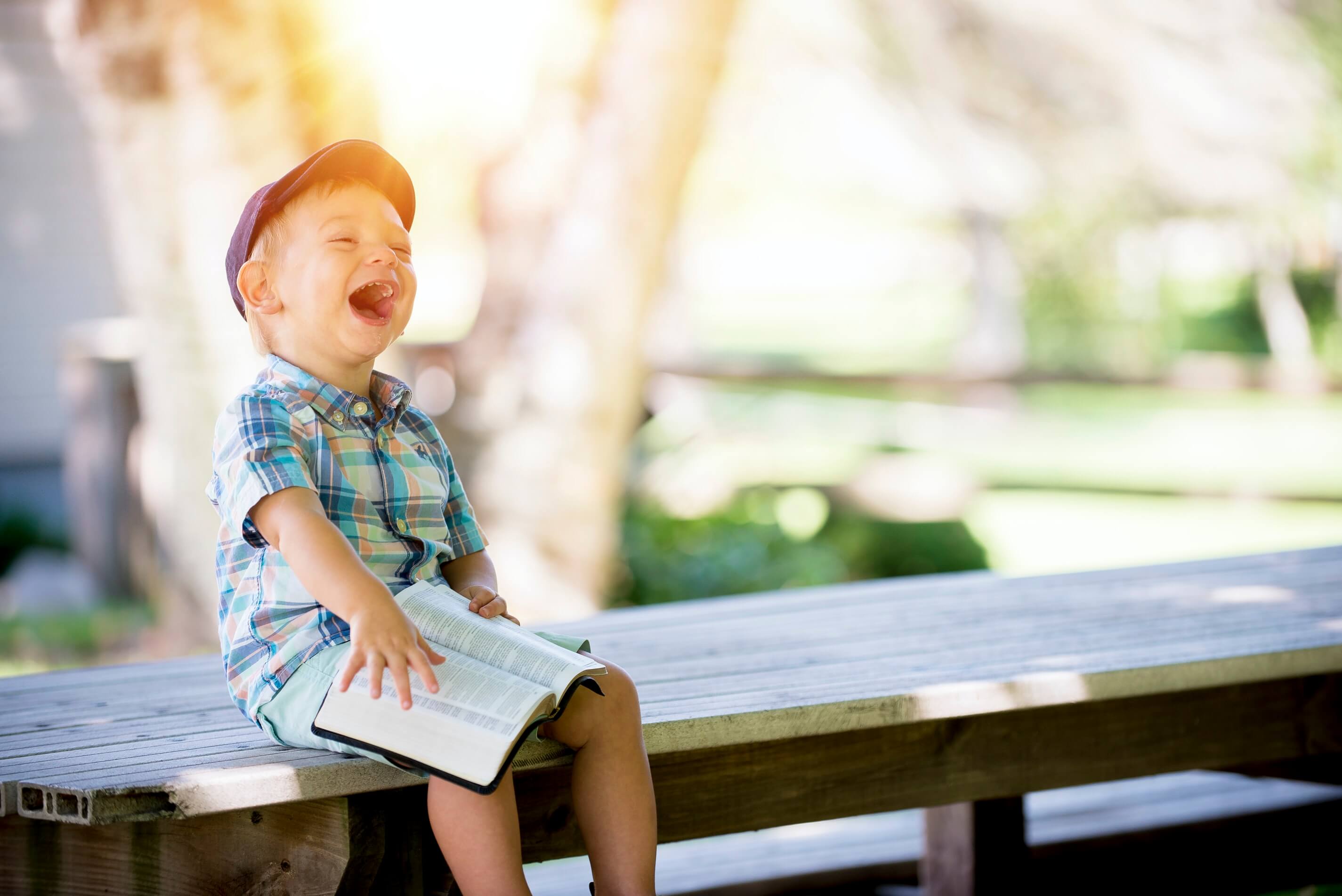 early childhood teacher job with young boy on park bench